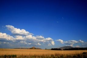 white clouds over the yellow ochre fields on a sunny day