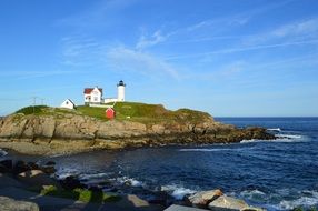 sea lighthouse on green cliff