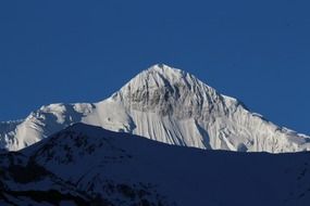 snow on top of a mountain against a blue sky