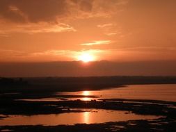 orange sunset cloudy sky over the river