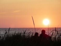 people watch the sunset on the north sea