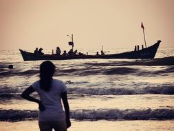 long boat with people in the ocean at dusk