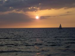 distant view of a sailboat in hawaii at sunset