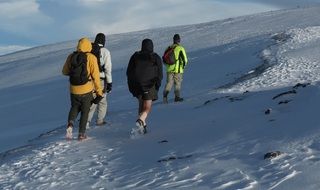 people Climbing a mountain in the snow