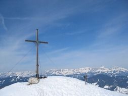 cross at the peak of a snowy mountain in Wagrain, Austria