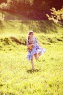 barefoot girl with teddy bear runs on the meadow