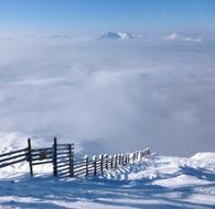 wooden fence in the snowy alps