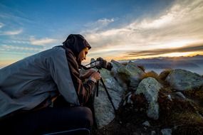 photographer shooting sunset in mountains