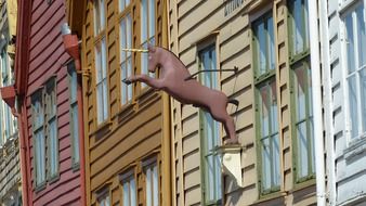 street decoration of unicorn on facade of Bryggen, also known as Tyskebryggen, colorful Hanseatic heritage commercial buildings in line, norway, Bergen