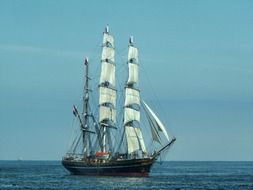 beautiful sailing ship with white sails in the ocean