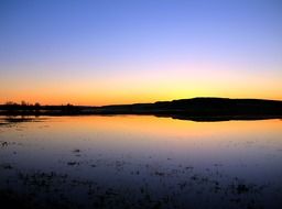 blue sky and blue water and blazing sun sunset