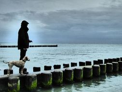 man with a dog in the baltic sea beach