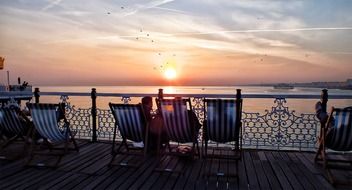 sun beds on the pier at sunset