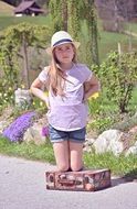 child girl blond hat with personal luggage