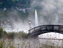 bridge in the haze on the background of the fountain