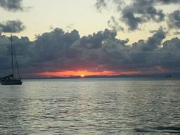 red sun between the blue sea and sky