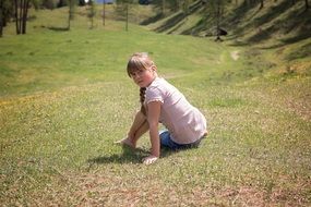 child girl sitting on meadow