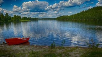 red boat on the shore of lake saxen in sweden