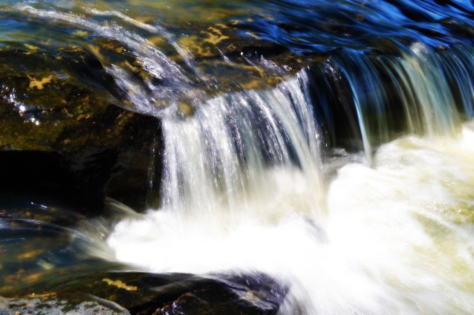 photo of a cascade of a mountain river in the wild