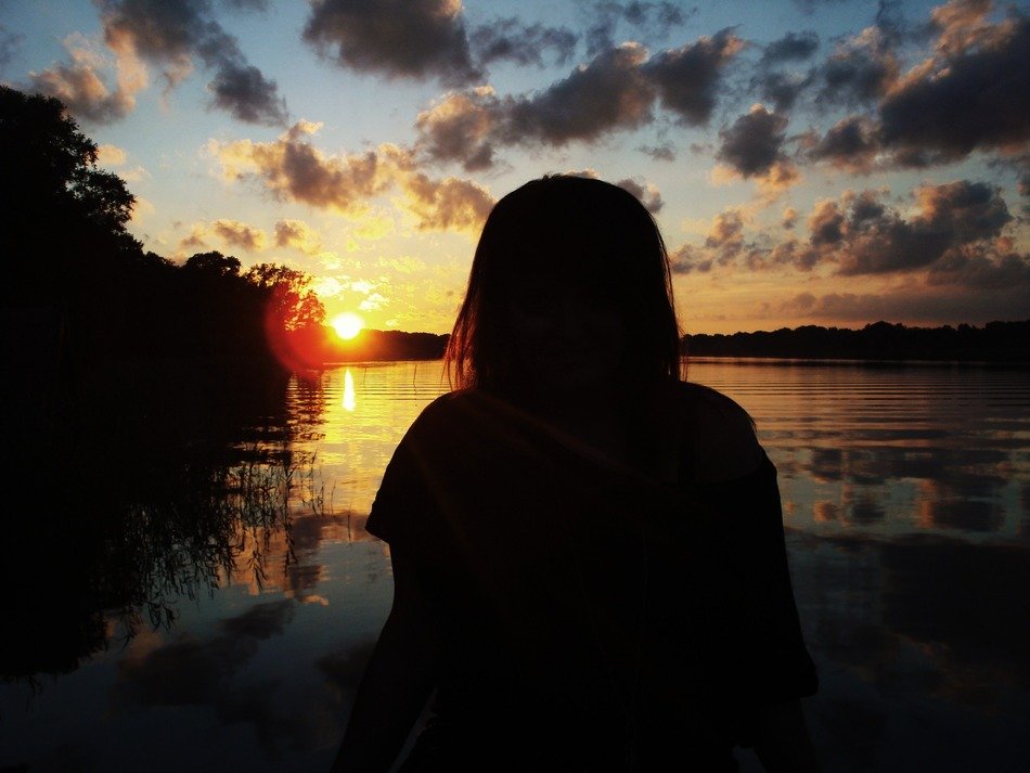shadow of a girl at sunset by the water
