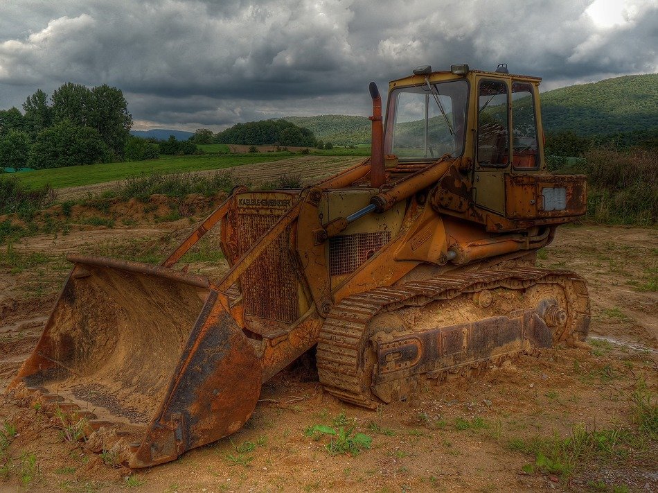 Rusty excavator in the forest in stormy weather