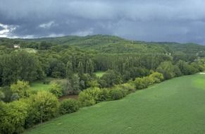 panoramic view of storm clouds over a green forest