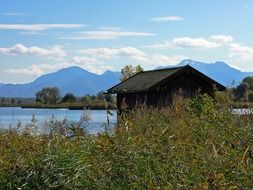landscape of small house on a lake bank on a sunny day