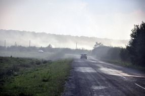 Car on the road in smoke in the countryside