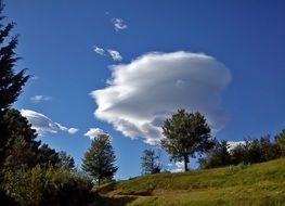 cumulonimbus clouds over green hill