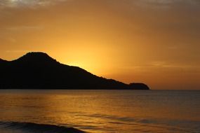 Orange sky over a hill near the ocean
