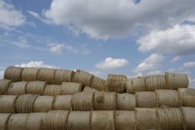 Stacked straw bales in countryside under blue sky with white clouds in Edemissen, Germant