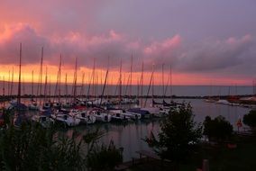 sailboats on a pier on Lake Balaton on a background of purple sunset