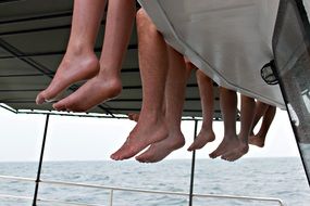 legs dangling from pier