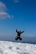 Man is jumping on the snowy mountain