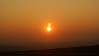 bright setting sun in cloudy haze