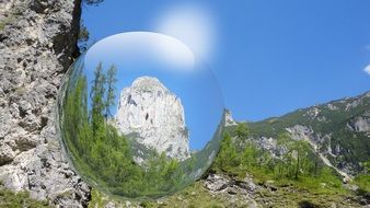Transparent ball on the background of the beautiful Alpine mountains with plants in Austria