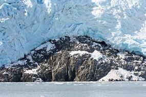 blue glacier on rocky coast, usa, alaska
