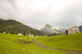 rainbow over the countryside in the alps