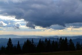 Cloud over a hill with green trees