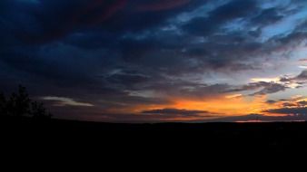 dark sunset and golden sunbeams over the plain