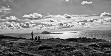 black and white photo of a family on a rocky beach