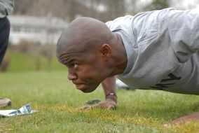 The athlete is pushing up on a green field