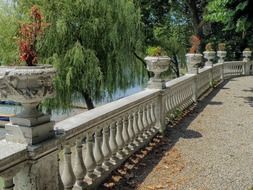 stone carved vases with plants on railing of palace, italy, sesto calende