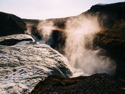 foggy haze over a waterfall on a sunny day