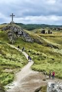 people on path to cross at hilltop
