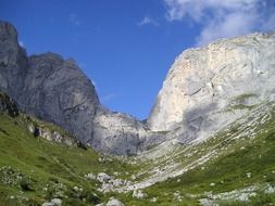 Beautiful steep wall at blue sky with white clouds background in the Kirchlispitzen mountains of Switzerland