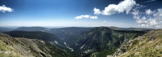 gorgeous dark mountains under blue sky with white clouds