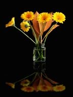 yellow flowers in vase reflection on black surface