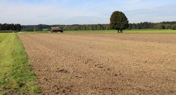 farm building on meadow near plowed field