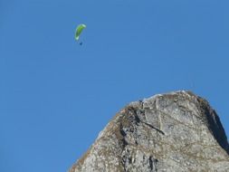 glider soars over a mountain ridge